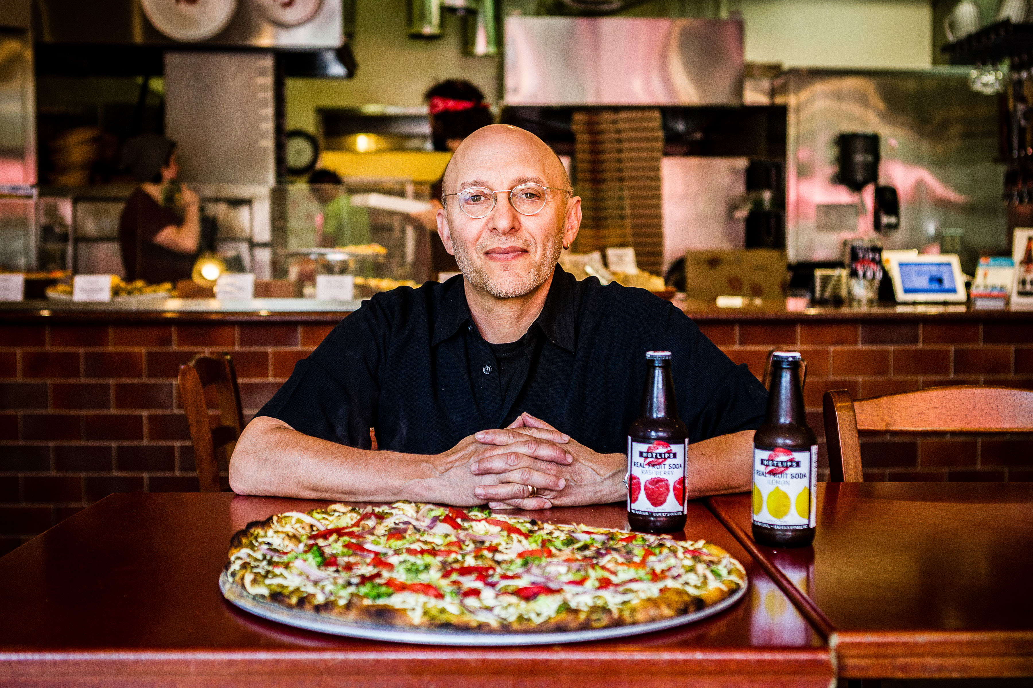David Yudkin, Founder of Hot Lips Pizza pictured behind pizza pie