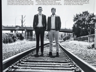 Oliver Alexander and Orion Falvey standing on railroad track for environmental portrait