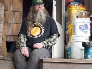 Tim McCarthy, former chairperson of Dignity Village sits on porch