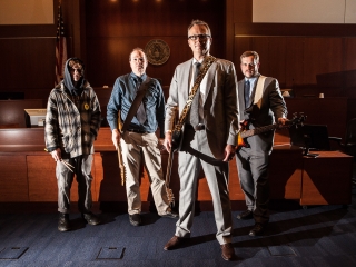 Band of Lawyers standing in courtroom with guitars in Oregon