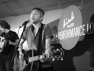 The Bodeans lead singer plays guitar and sings at the KINK Live Performance Lounge