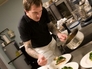 Chef Aaron Solley at James John Cafe setting course plates out in kitchen