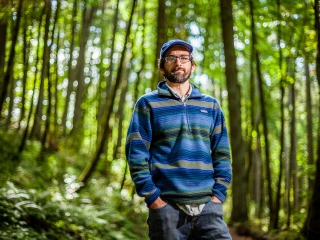 Portrait of Eugene Conservationist standing in forest with blue hat