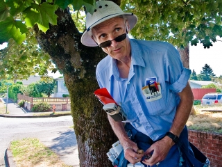 Jamie Partridge, mail carrier in Northeast Portland looking out under tree