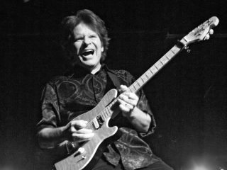 John Forgarty sings and plays guitar during a concert in Portland.